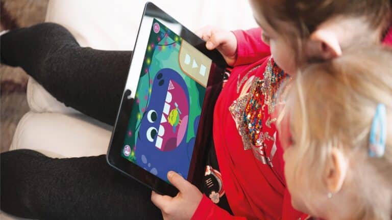 Child using an AI-powered learning app on a tablet with parent guidance at home